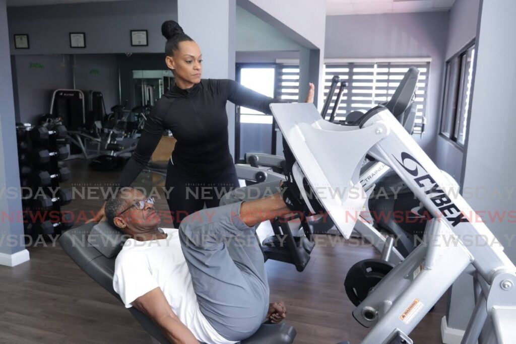 Personal trainer Tricia Thompson counts reps for Mr Ventour during a training session on August 28 at One80 Fitness Studio. - Photo by Grevic Alvarado 