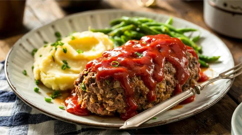 meatloaf and mashed potatoes served with ketchup and green beans