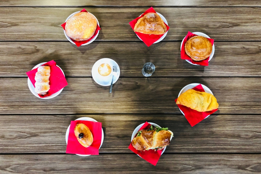 Overview of pastries and drinks placed on a table in a circular configuration.