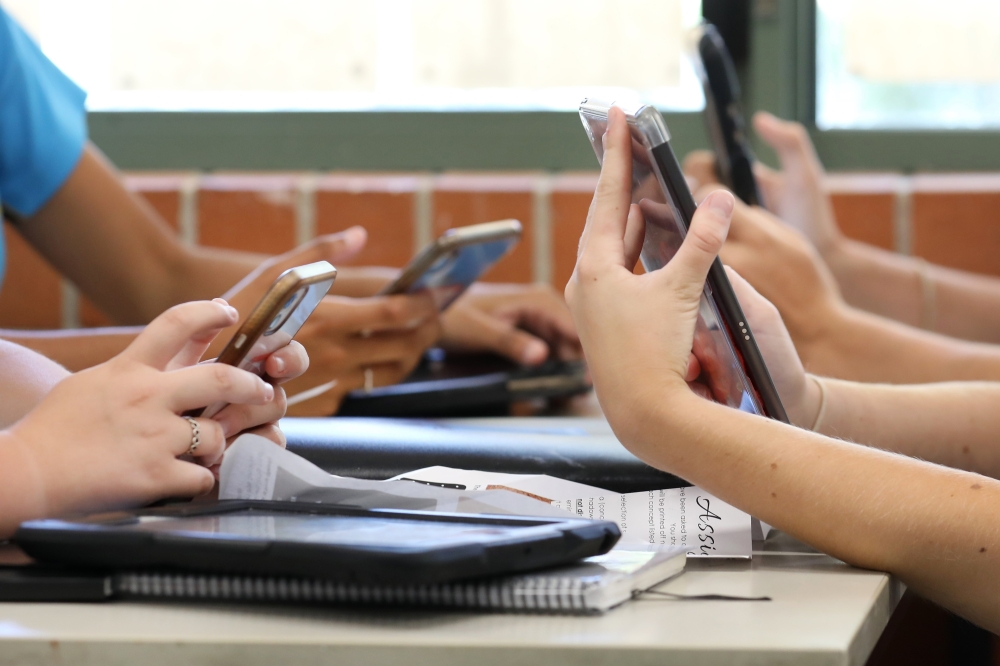 hands of students using phones