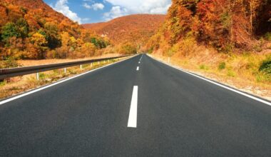 Driving on asphalt road through the hills at autumn.