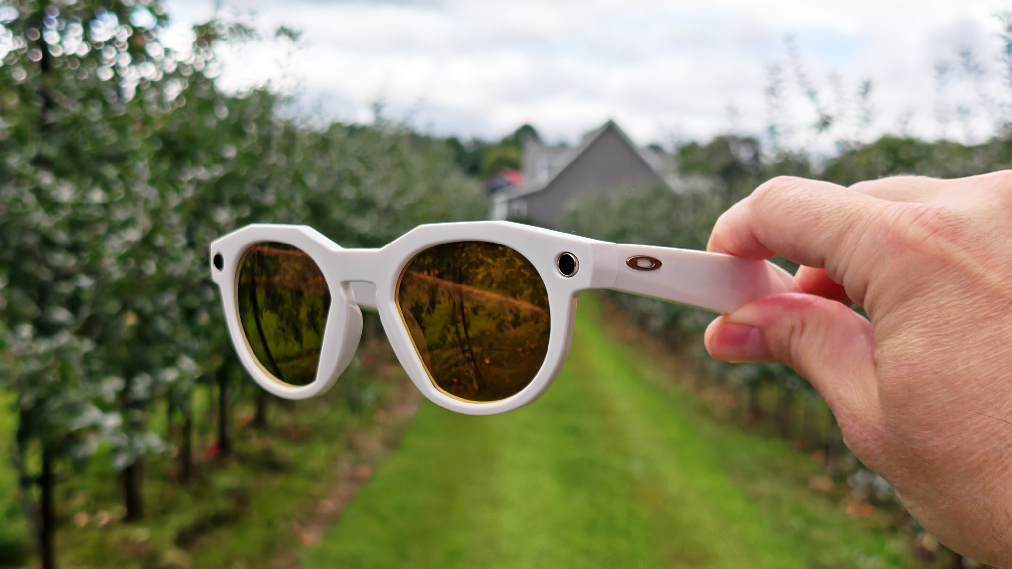 Holding a pair of limited edition warm white Oakley Meta HSTN smart glasses