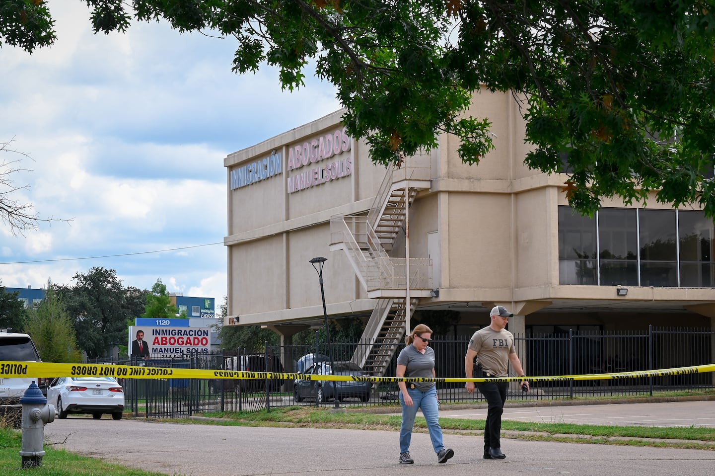 Investigators worked the scene near a building where authorities say 29-year-old Joshua Jahn fired indiscriminately from the rooftop toward a Dallas immigration field office last week.