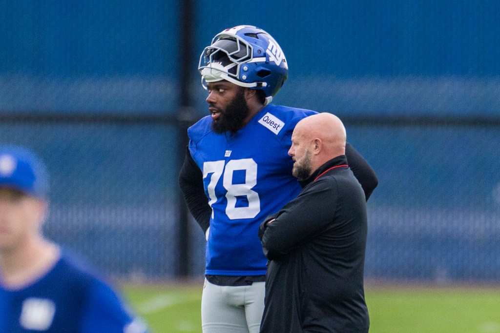 New York Giants player Andrew Thomas speaks with head coach Brian Daboll.