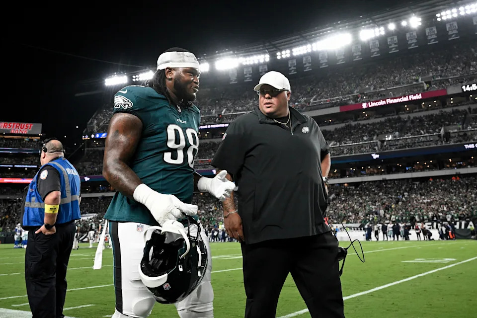 Philadelphia Eagles defensive tackle Jalen Carter (98) is escorted off the field by senior advisor Dom DiSandro after being eject during the first half of an NFL football game against the Dallas Cowboys, Thursday, Sept. 4, 2025, in Philadelphia. (AP Photo/Terrance Williams)