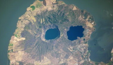 A satellite photo of a rounded peninsula in a lake, with two eye-like lakes at its center