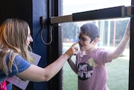 Zachary Kramer presses his face against a glass door while playing on the playground to say...