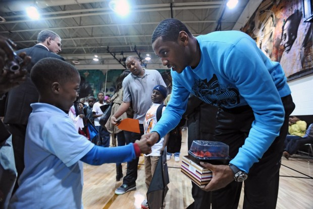 Carmelo Anthony, of the New York Knicks, a former Towson Catholic student, pays a surprise visit to kids at the Carmelo Anthony Youth Development Center. Tyion Taylor, 6, left, a first-grader at Inner Harbor East Academy, shakes hands with Anthony after giving him a strawberry cheesecake.