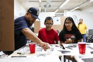 Gallery 86 co-owner Nicolas Gonzalez (left) instructs as David, 12, (center) and his sister...