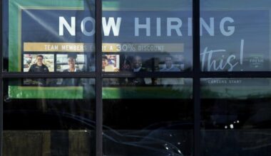 A hiring sign is displayed at a grocery store