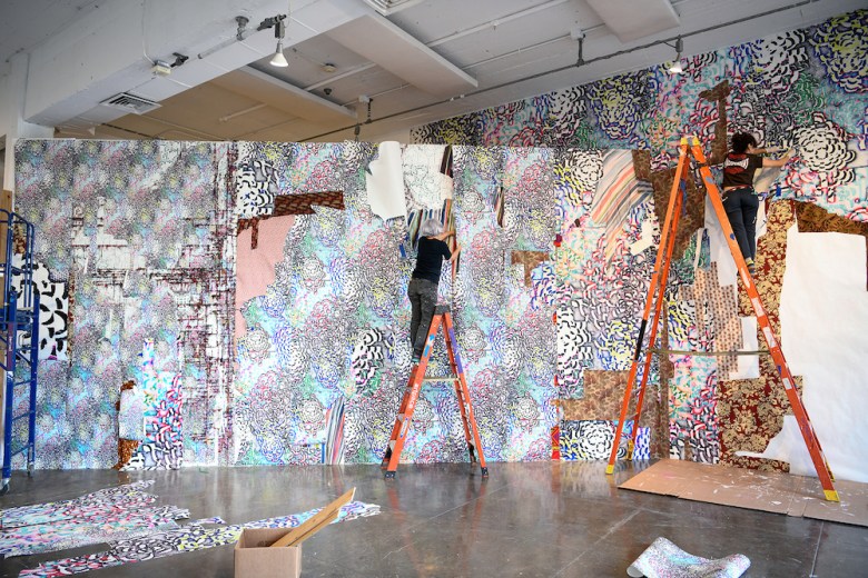 Artist Elana Herzog and her studio assistant Madelynn Mesa installing Global Floral at Artpace.