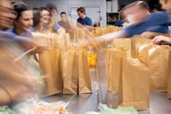 Volunteers from Accelerate Investment Partners prepare meal packs for DISD kids at Hunger...