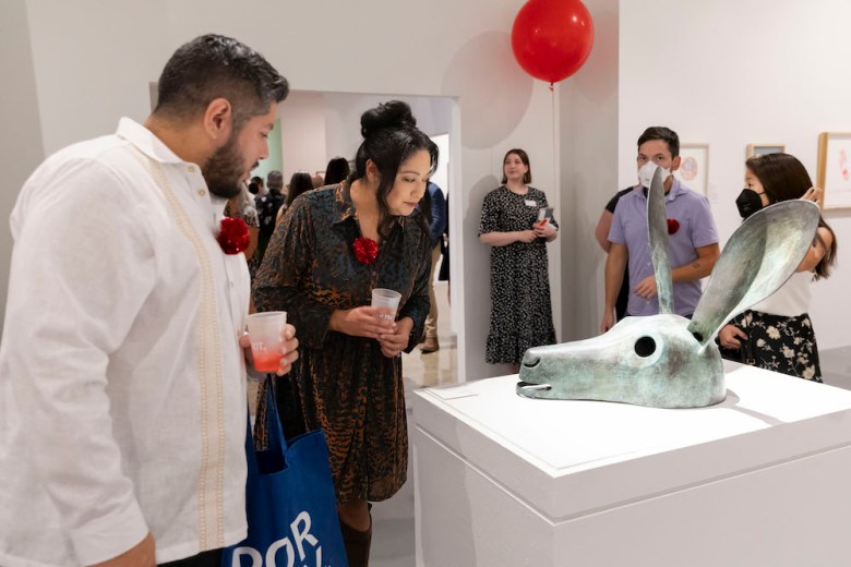 Visitors to the 2024 Red Dot Sale peruse works of art.