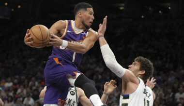 Phoenix Suns guard Devin Booker drives between Milwaukee Bucks guard AJ Green (20) and center Brook...