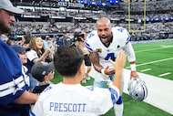 Dallas Cowboys quarterback Dak Prescott  interacts with young fans on the sidelines before...