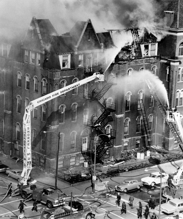 Firefighters in snorkel baskets direct streams of water onto a fire on Sept. 13, 1963 at Mercy Hospital on the South Side. (Luigi Mendicino/Chicago Tribune)