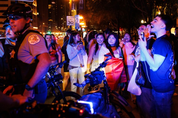 Celebrating Mexican Independence Day, revelers confront Chicago Police while they stop a vehicle with a Mexican flag near Michigan Avenue, Sept. 13, 2025. (Armando L. Sanchez/Chicago Tribune)