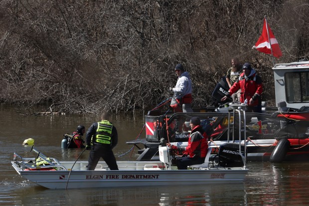 Divers work on securing the car of Karen Schepers in...