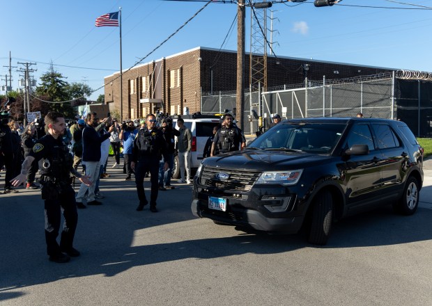 A federal agent drives off after being blocked by protesters...
