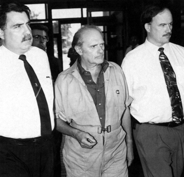 Chicago police investigators Richard Schak, left, and Louis Rabbit lead Kenneth Hansen on Aug. 12, 1994 through the Grand Central Area station. (Val Mazzenga/Chicago Tribune)