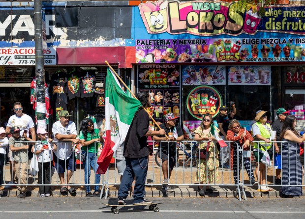 A skateboarder carries a flag in the annual 26th Street...