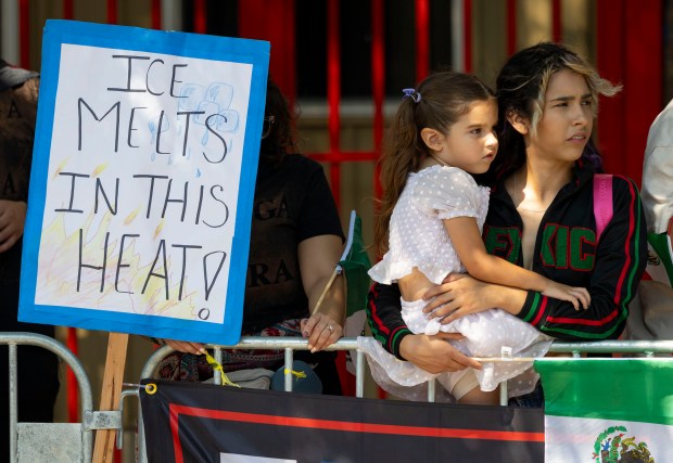 People post a sign about ICE during the annual 26th...