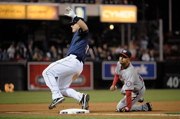 Padres' Anthony Rizzo goes into third base with a triple in front of the Nationals' Alex Cora during the fifth inning at Petco Park on June 9, 2011 in San Diego. (Denis Poroy/Getty)