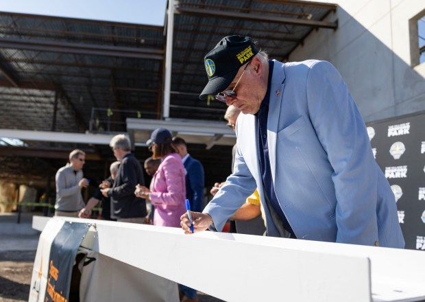 Bedford Park Village President David Brady signs the final beam as the Chicago Sky mark a construction milestone on their new practice facility Wednesday, Sept. 17, 2025, at the Wintrust Sports Complex. (Brian Cassella/Chicago Tribune)