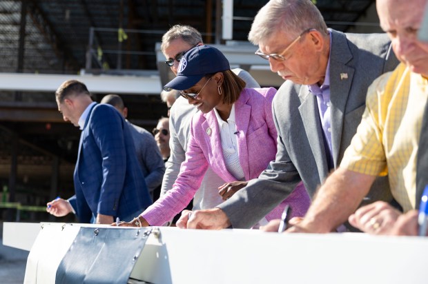 Chicago Sky co-owner and operating chairman Nadia Rawlinson, center, signs the final beam with other team and village officials as they mark a construction milestone on their new practice facility Wednesday, Sept. 17, 2025, at the Wintrust Sports Complex in Bedford Park. (Brian Cassella/Chicago Tribune)