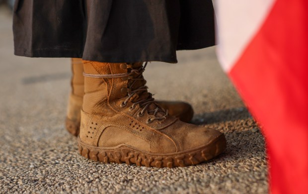 Lina Alvarez, a retired U.S. Army National Guard sergeant first class, wears her army boots underneath a traditional Mexican dress as she protests in front of the Naval Station Great Lakes on Sept. 10, 2025, in North Chicago. (Stacey Wescott/Chicago Tribune)