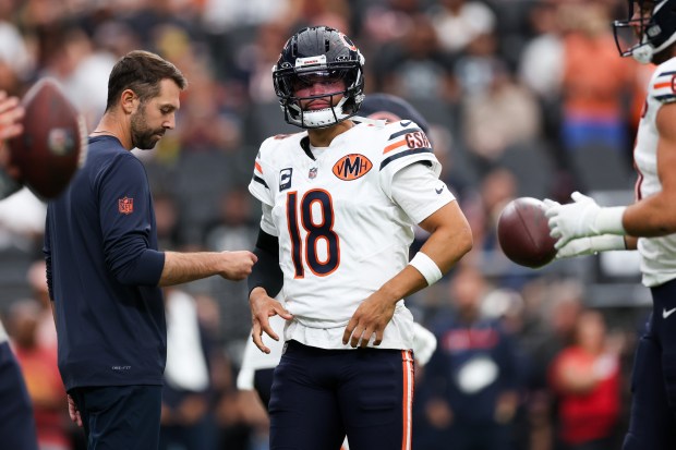 Chicago Bears quarterback Caleb Williams (18) walks on the field...