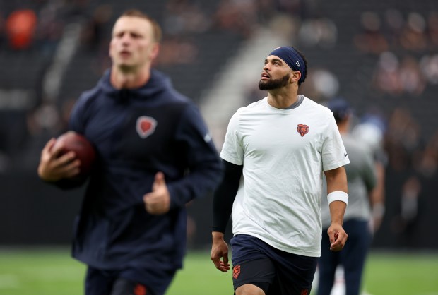 Chicago Bears quarterbacks Caleb Williams (right) and Tyson Bagent warm...