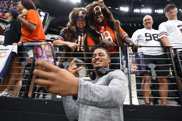 Chicago Bears wide receiver Rome Odunze takes a photograph with...