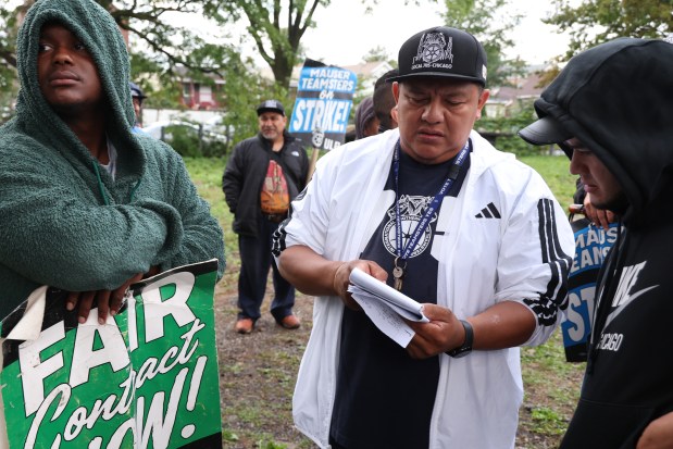 Dante Woodson, from left, and Arturo Landa gather with fellow striking Mauser Packaging Solutions in Chicago, Aug. 28, 2025. (Antonio Perez/Chicago Tribune)