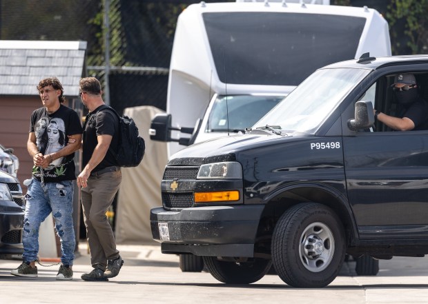 A federal agent escorts a detainee into the Immigration and...