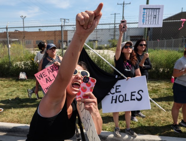 A protester yells “Shame!” at federal agents during a protest...