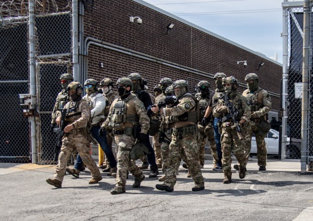 Federal agents emerge from the Immigration and Customs Enforcement facility...