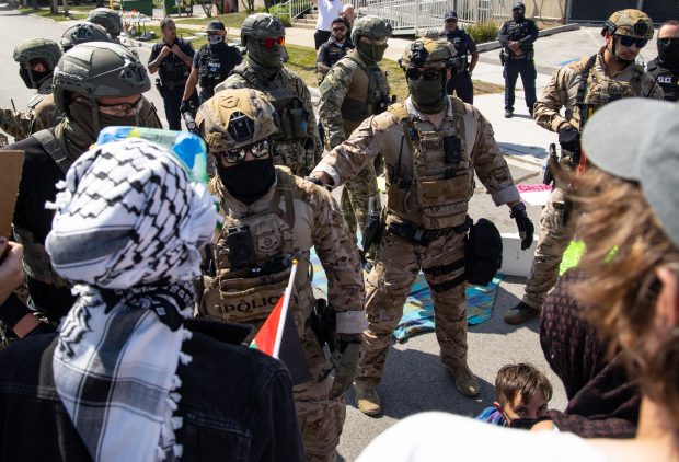 Protesters stand face to face with federal agents at the...