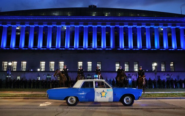Vintage Chicago police vehicles are driven in front of Soldier Field during the Chicago Police Memorial Foundation's annual candlelight vigil at the Gold Star Families Memorial on Sept. 10, 2025. (Chris Sweda/Chicago Tribune)