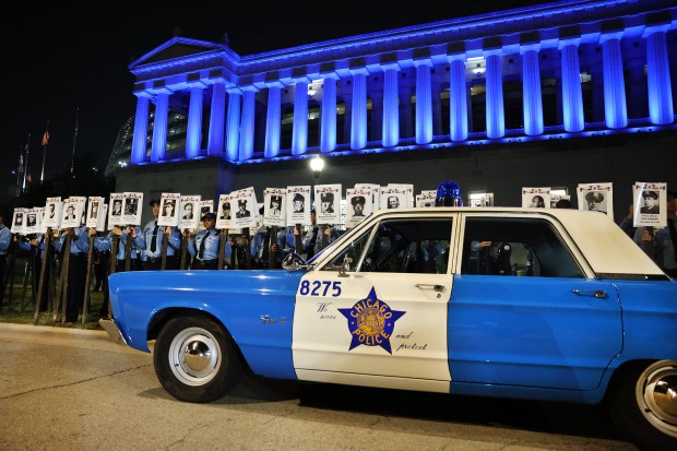 Chicago Police Department recruits hold up images of some of the 607 fallen Chicago police officers during the Chicago Police Memorial Foundation's annual candlelight vigil at the Gold Star Families Memorial on Sept. 10, 2025. (Chris Sweda/Chicago Tribune)