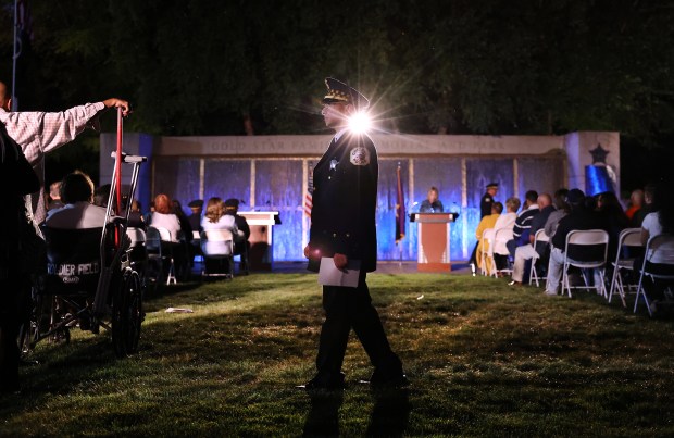 A Chicago police officer walks across the grass while attending the annual Chicago Police Memorial Foundation's annual candlelight vigil on Sept. 10, 2025. (Chris Sweda/Chicago Tribune)