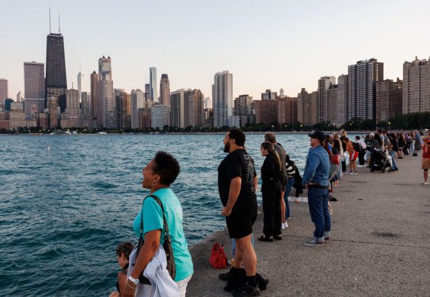 A group of people face Lake Michigan and scream during the eleventh scream club gathering near North Avenue Beach on Aug. 31, 2025, in Chicago. (Armando L. Sanchez/Chicago Tribune)