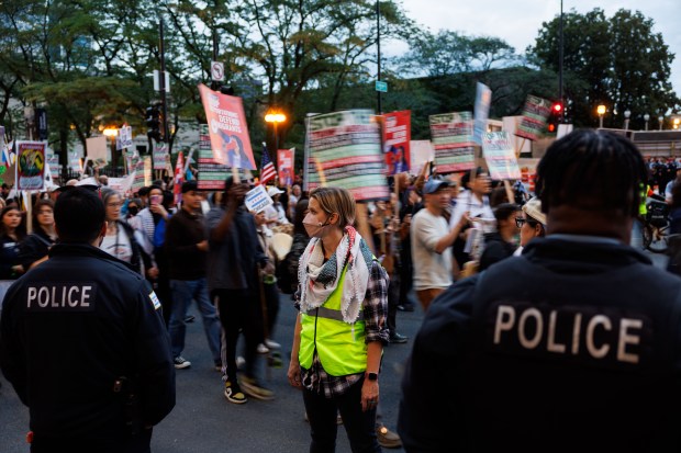 Chicago police stand along North Michigan Avenue as people march to protest President Donald Trump's intent to increase immigration enforcement actions in the city and deploy the National Guard, Sept. 6, 2025, in Chicago. (Armando L. Sanchez/Chicago Tribune)