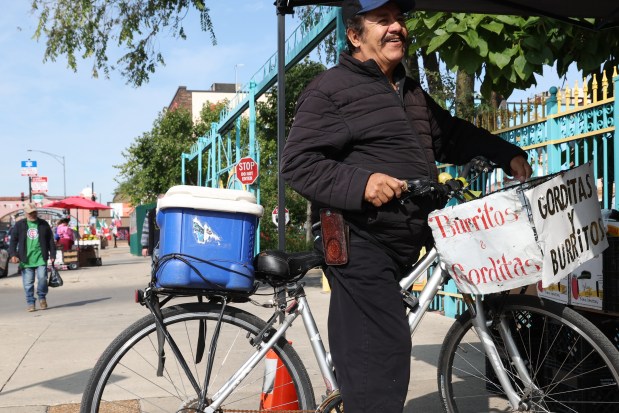 Vendor Reynaldo Martinez on his bike after selling all his burritos and gorditas, Sept. 9, 2025, in Chicago. (Antonio Perez/Chicago Tribune)
