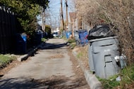 Trash cans are seen in an alley in Dallas in February 2024. The city plans to end alley...