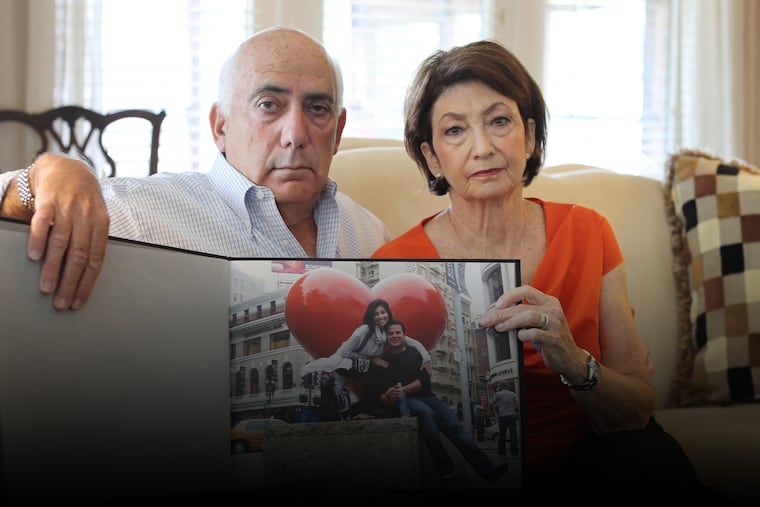 Ellen Greenberg's parents, Joshua and Sandra Greenberg, hold a photo album of their daughter.