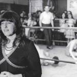A woman standing next to a boxing ring.