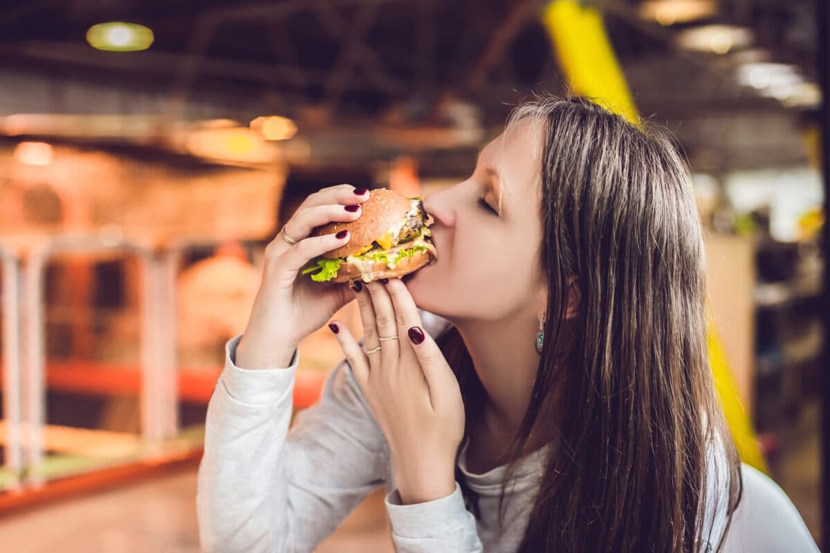 Woman eating a hamburger or cheeseburger