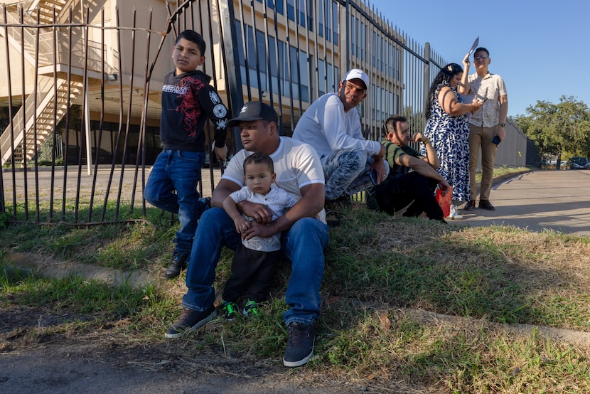 Edixon Delgado waits with two of his sons oustide the U.S. Immigration and Customs...
