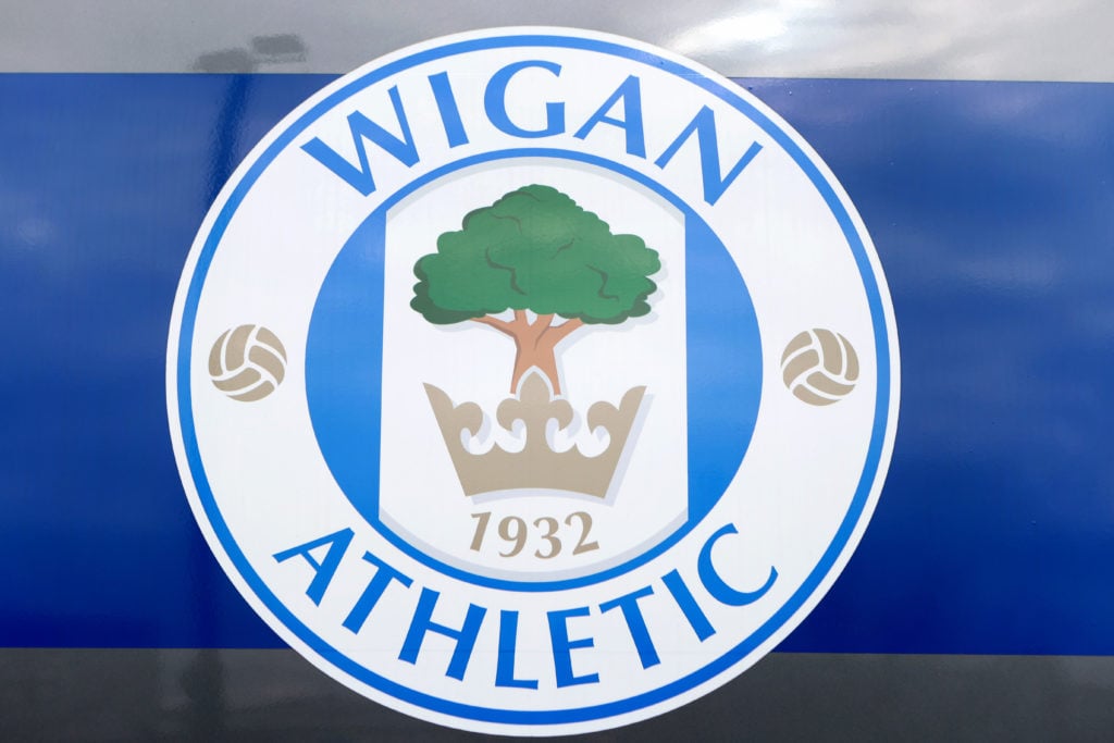 The club crest of Wigan Athletic is seen outside DW Stadium prior to the Sky Bet League One match between Wigan Athletic and Ipswich Town